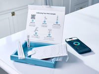 Open pet microbiome analysis kit on a bathroom counter, showing swabs, sample tube, mailing envelope, and beneficial bacteria results.