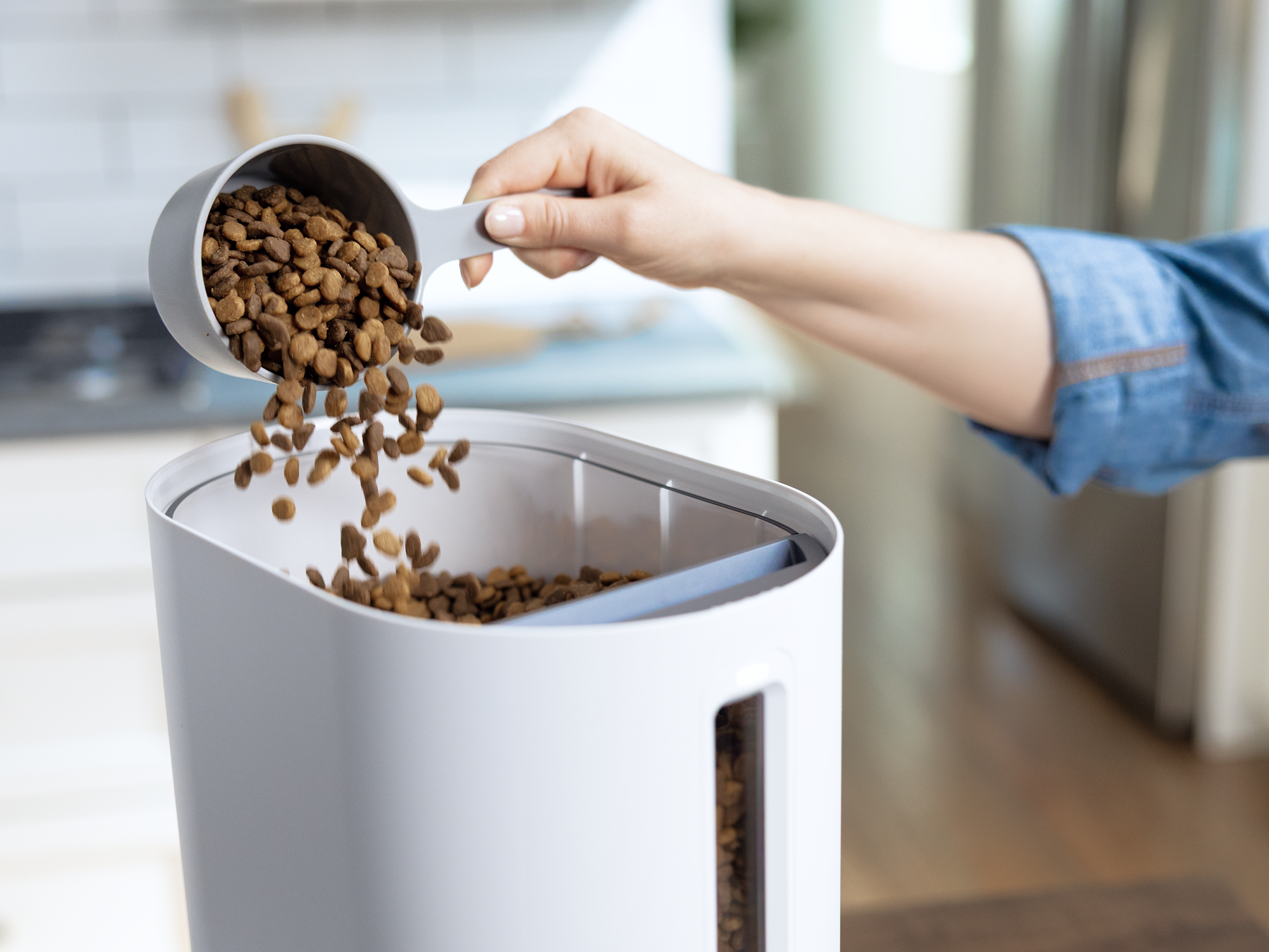 Filling Petivity Smart Feeder for Cats with dry food kibble through top-loading compartment