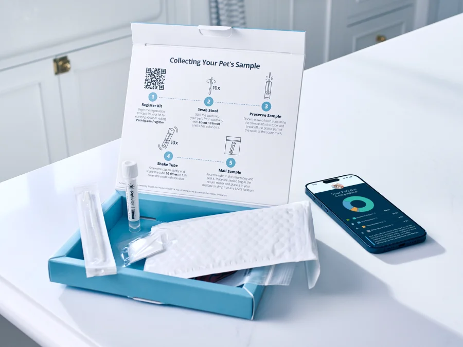 Microbiome analysis kit unboxing with sample collection instructions, test tube, protective pouch, and a smartphone displaying test results