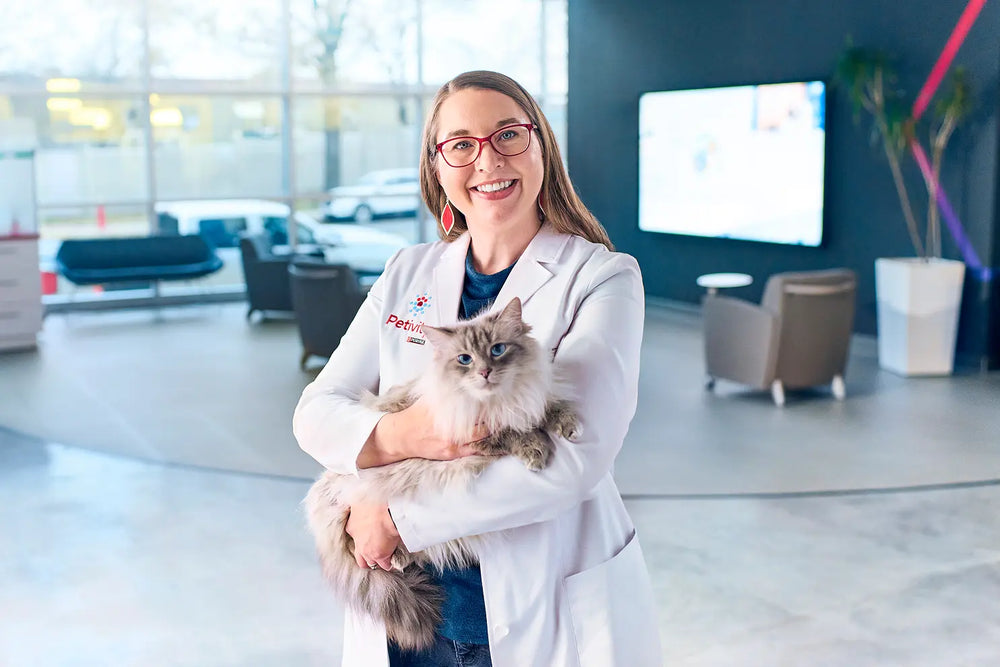 woman wearing petivity veterinarian jacket holding a cat